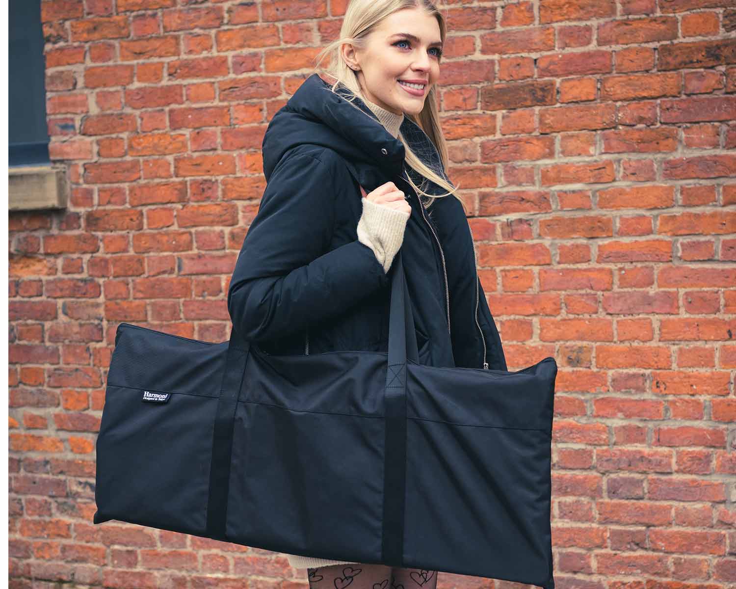 woman carrying a bad with the harmoni desk